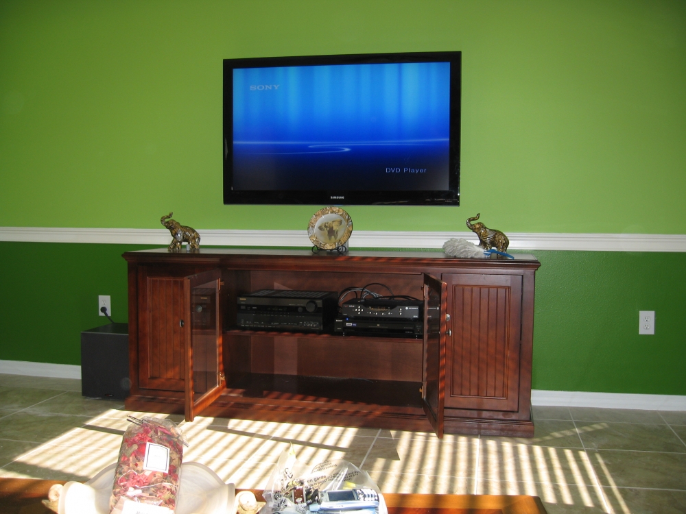 Television mounted on green wall
